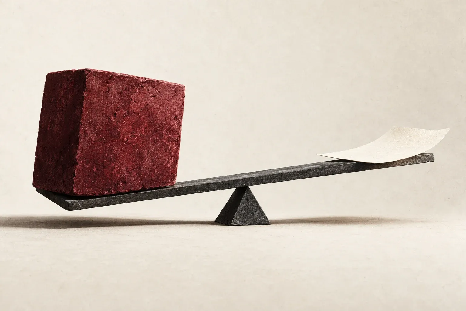 A heavy block and a light paper sheet on a balance.